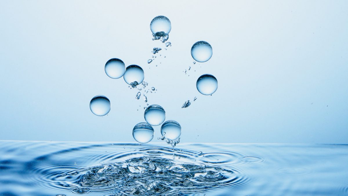Waterdruppels boven het wateroppervlak